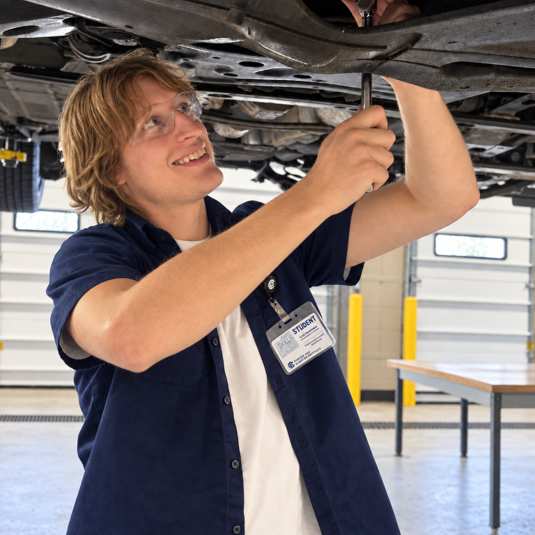 Liam Henderson working beneath a vehicle